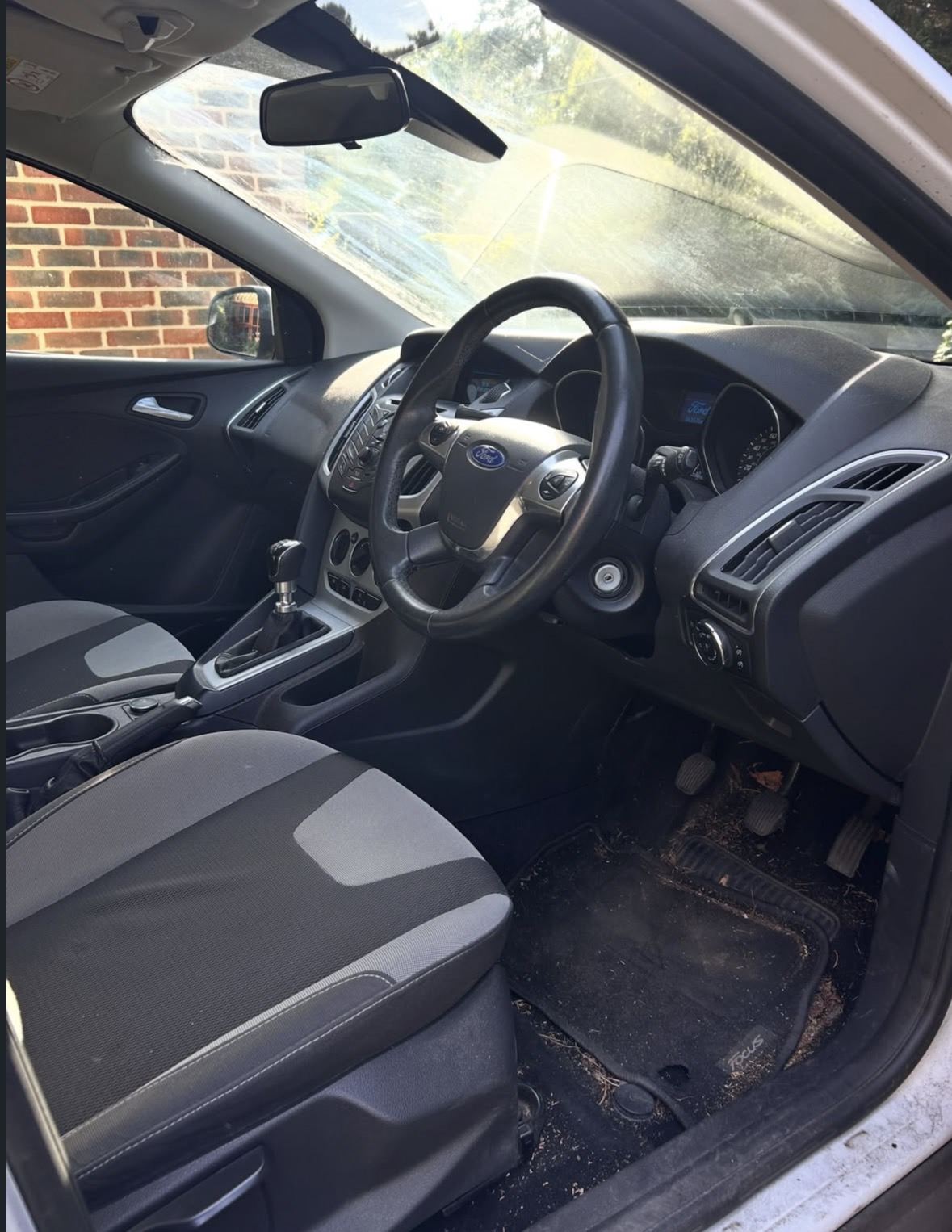 Before: Ford Focus interior with a grimy windscreen and leaves in the footwell