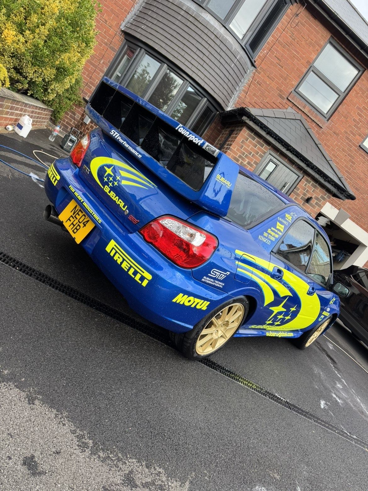 Rear view of the Subaru showing the big wing and glossy rally livery